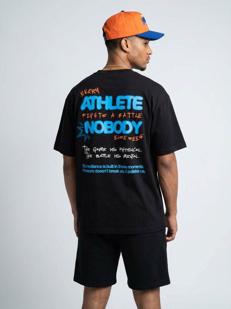 Person wearing a black t-shirt with motivational text on the back, standing against a plain background.