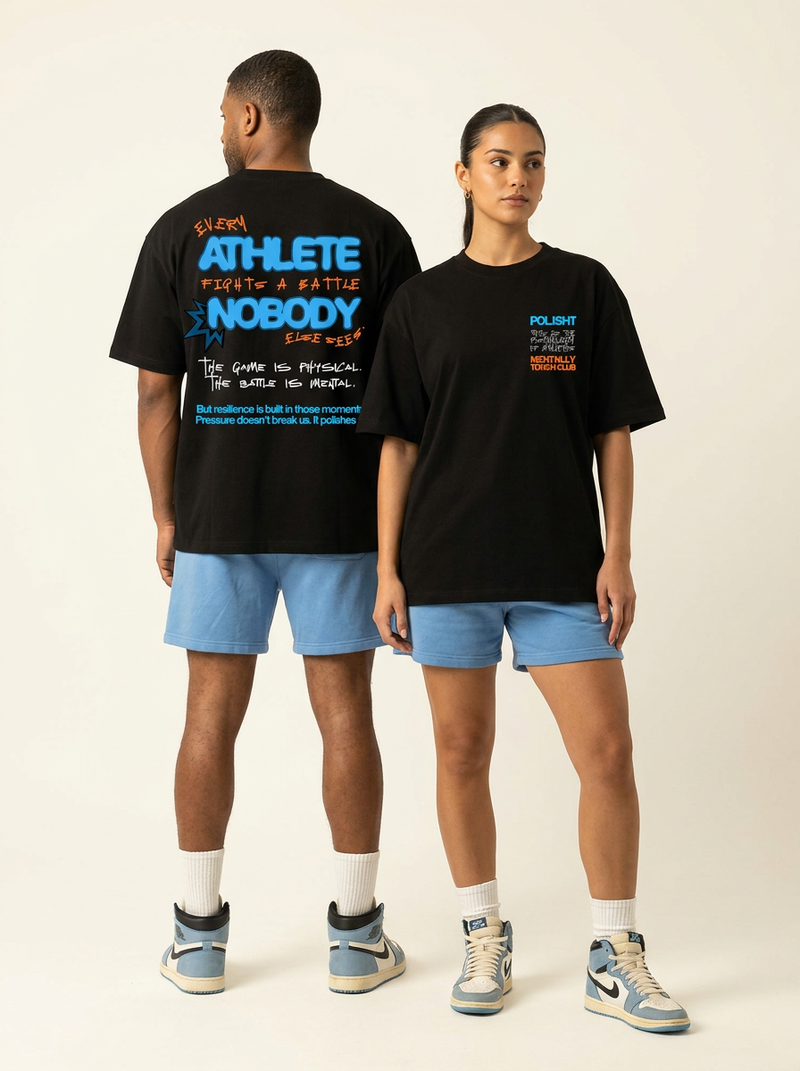 Two people wearing black t-shirts with text, standing back-to-back against a plain background.