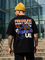 Person wearing a black t-shirt with colorful text and graphics, standing outdoors.