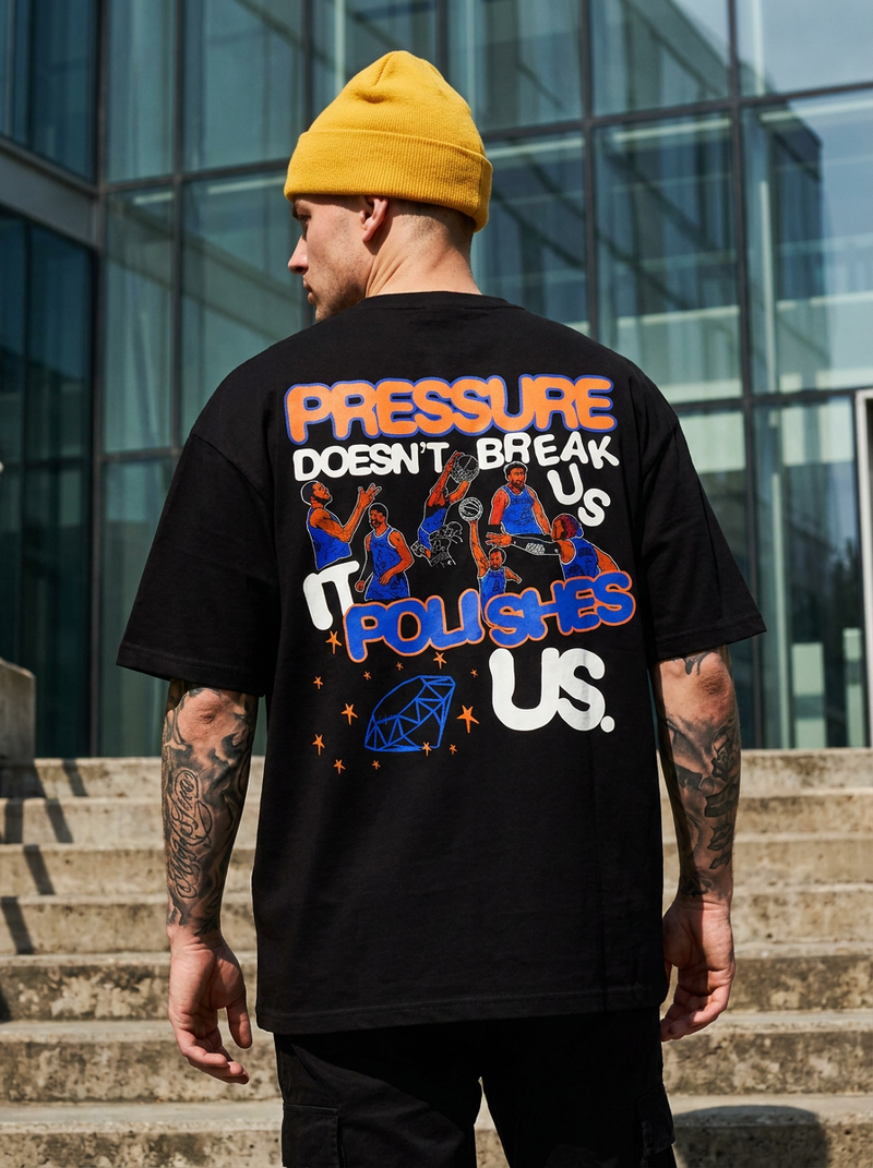 Person wearing a black t-shirt with colorful text and graphics, standing outdoors.